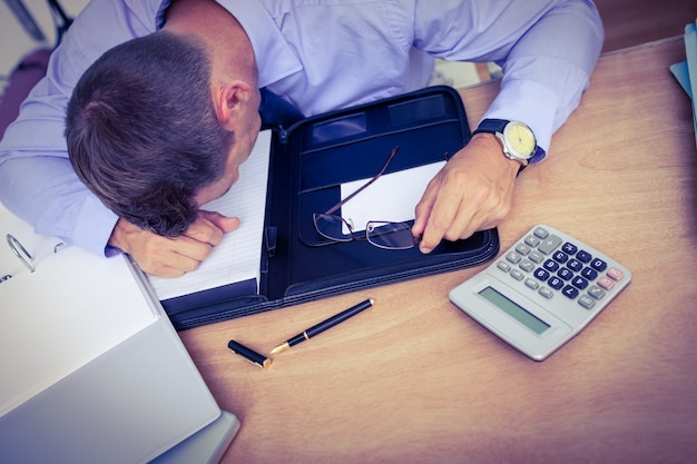 Exhausted businessman sleeping on the desk