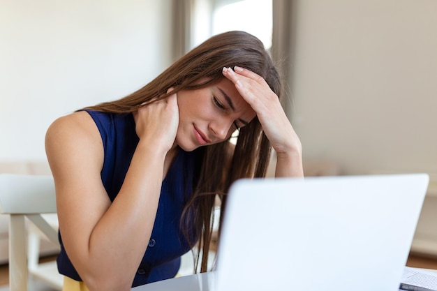exhausted businesswoman having a headache in home office creative woman working at office desk feeling tired