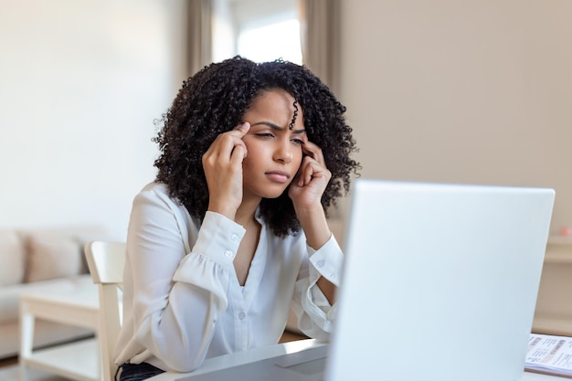 Exhausted businesswoman having a headache in home office