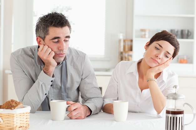 Photo exhausted couple drinking coffee