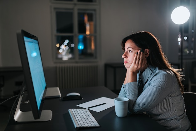 Exhausted entrepreneur looking at computer screen.