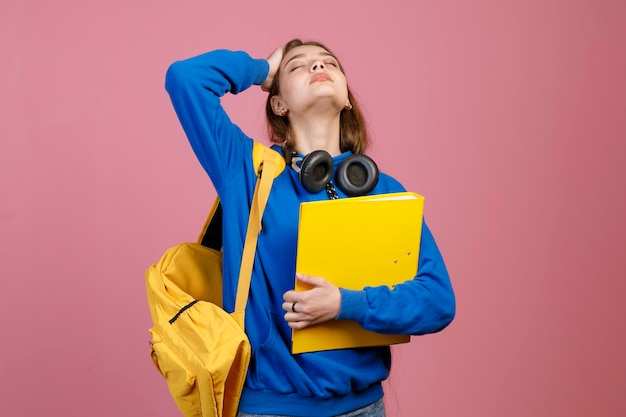 Exhausted female student standing with closed eyes looking up