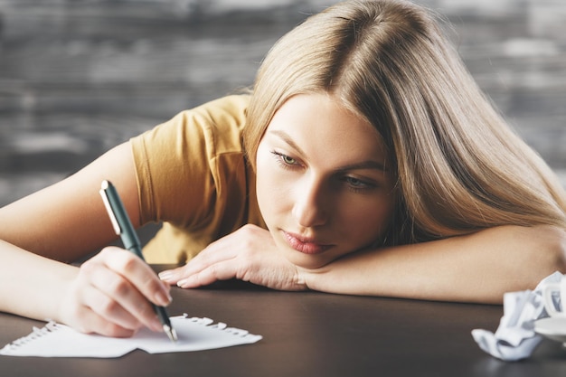 Exhausted lady writing on paper