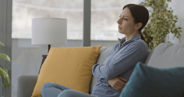 Exhausted lonely woman sitting on the couch