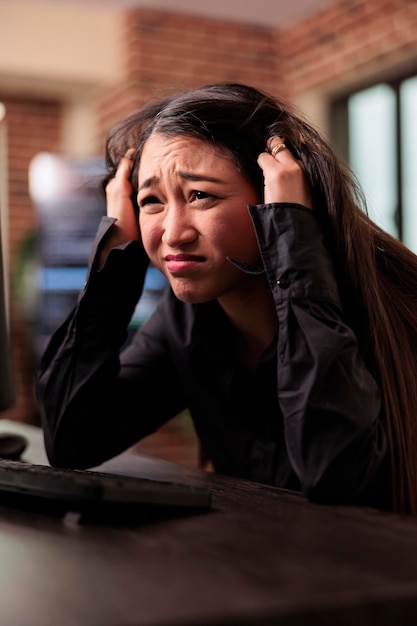exhausted programmer was struggling to keep up with the demands of the software development project, feeling the stress of overwork. coder writing ai algorithm and sitting at desk in it company.