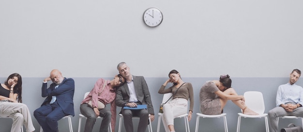 Foto persone esauste e stanche sedute sulle sedie e che si addormentano nella sala d'attesa