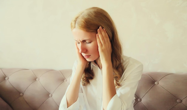 지친 피곤한 여성은 두통이나 사막 통증으로 집에서 머리에 편두통 긴장을 겪고 있습니다.