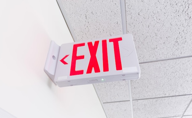 Photo exit sign against a dark background symbolizing safety and escape with green letters and arrow con