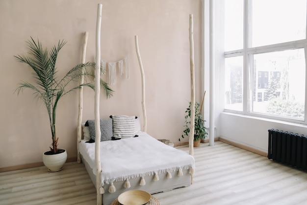 экзотический дизайн интерьера спальни кровать с деревянным балдахином и подушками, одеяло тропическая пальма