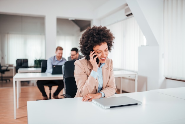 Foto donna di affari esotica che parla sul telefono in co ufficio lavorativo.