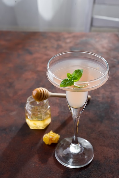 exotic cocktail, honey on brown stone background , copy space