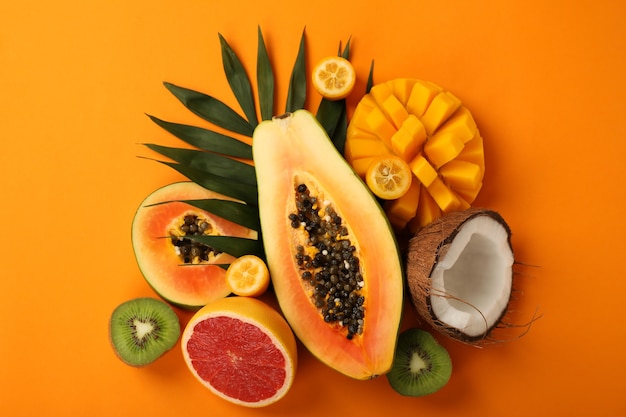 Exotic fruits set on orange background, top view.