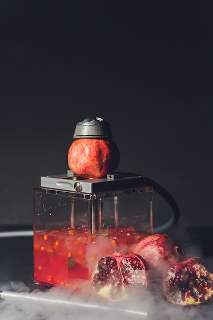 Foto shisha esotico fumante in stile orientale con aroma di tabacco di melograno. narghilè di frutta.