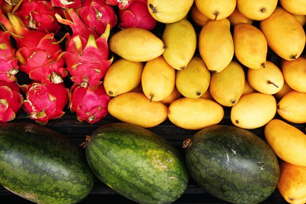 Exotic tropical fruits mango watermelon dragon fruit closeup on a market top view