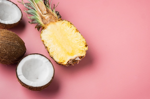 Exotic and tropical fruits, pineapple and Coconut set, on pink textured summer background, top view flat lay, with copy space for text