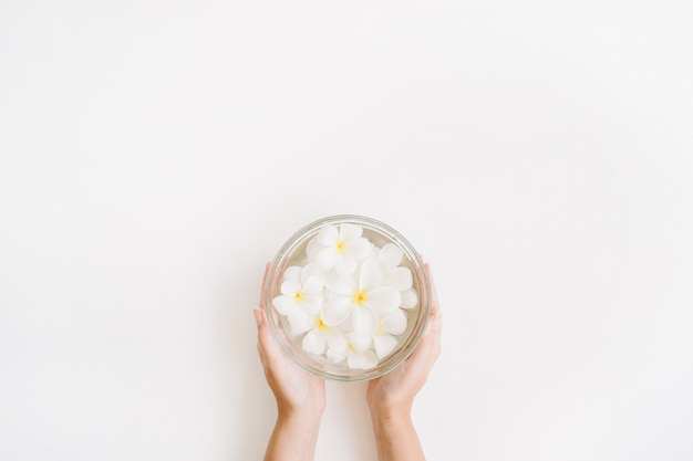 Exotic tropical palm flowers in girl's hands on white background.