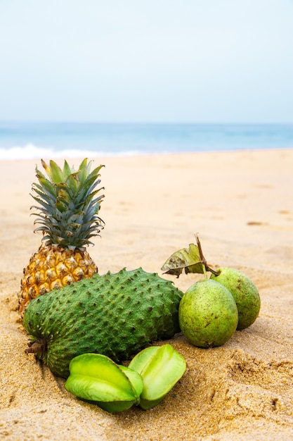 Exotisch fruit op het zand bij de oceaan