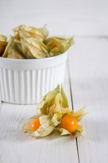 Exotische bessen physalis op een witte houten tafel.