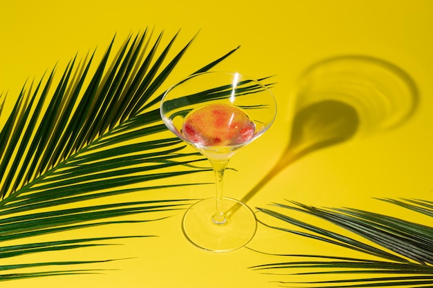 Exotische palmbladeren en cocktail in martini-glas met schaduw zomer tropisch drankje minimaal concept