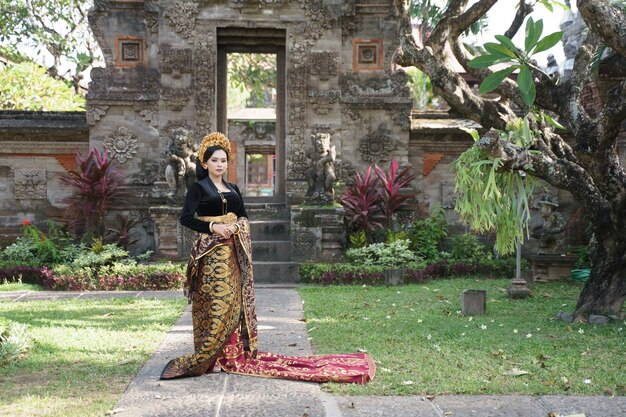 Exotische vrouw met balinese kebaya en endek geweven stof