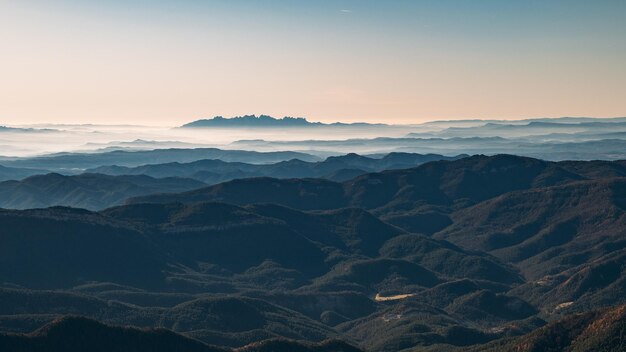 Photo expansive mountain vista with ethereal mist at dawn