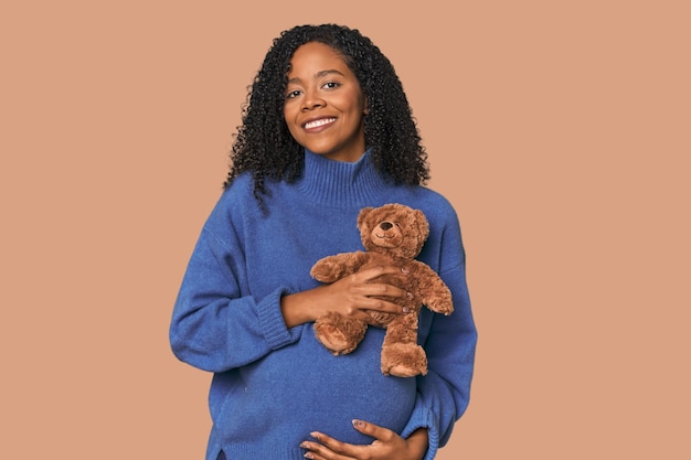 Expectant African American woman with teddy bear