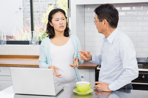 Expectant couple having argument in the kitchen