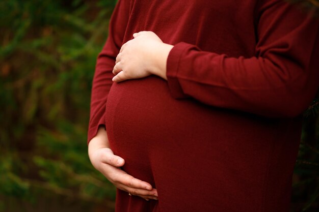 The expectant mother hugs the tummy in which the baby lives