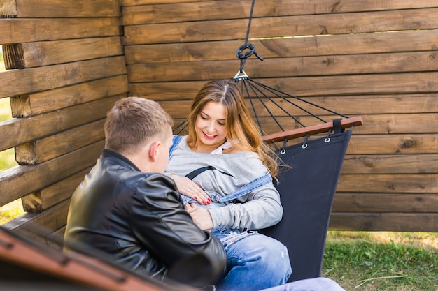 屋外のハンモックで妊娠中の若い愛情のあるカップル