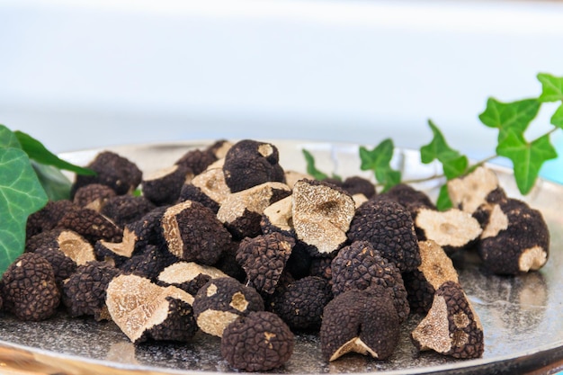 expensive black truffles gourmet mushrooms on the plate on a table