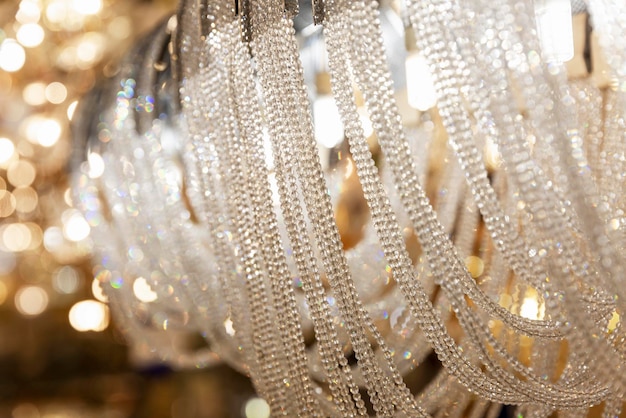 Expensive elegant crystal chandeliers in the salon Big choice Interior design Closeup