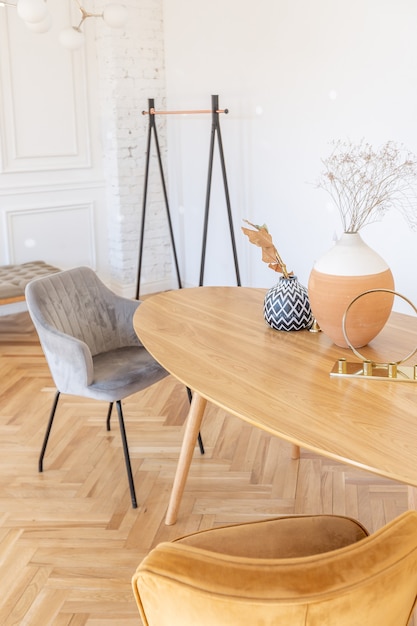 Expensive modern light luxury interior design of a spacious living room with wooden elements and white walls. filled with original and unusual decorative things