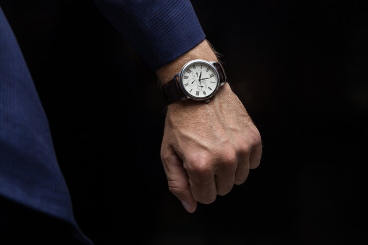 Photo expensive watch on the arm of a businessman in a blue suit black background