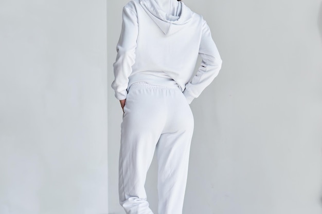 Experience the Ultimate in Casual Style with this Contemporary White Ensemble Sportwear mockup Girl in white pants Back view of a young woman wearing white minimalist sweatpants