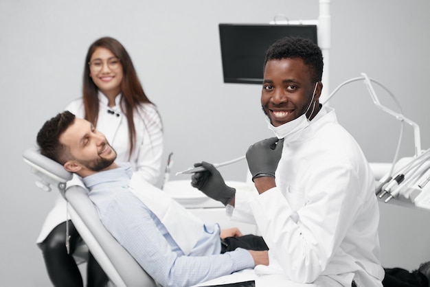 Photo experienced african dentist looking at camera and smiling