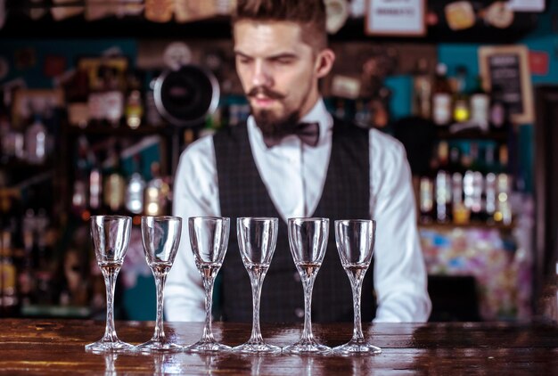 Photo experienced bartending places the finishing touches on a drink at bar