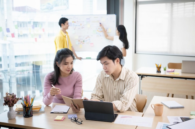 experienced businessman having a discussion with his female colleague at creative office