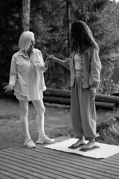 An experienced coach helps the girl stand barefoot on a board with nails.