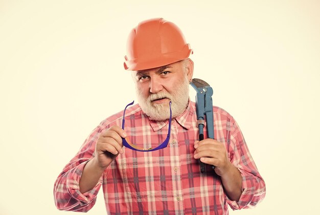 Experienced engineer home improvement plumber service man\
bearded plumber wear helmet and hold wrench tool repair concept\
sanitary engineering plumber workshop plumber repairing or\
renovating