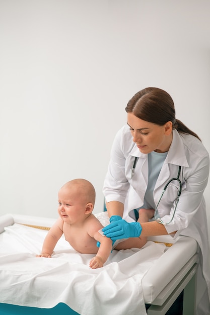 Experienced healthcare professional preparing a child for a shot