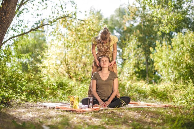 Experienced masseuse gives her client a refreshing massage out in the forest