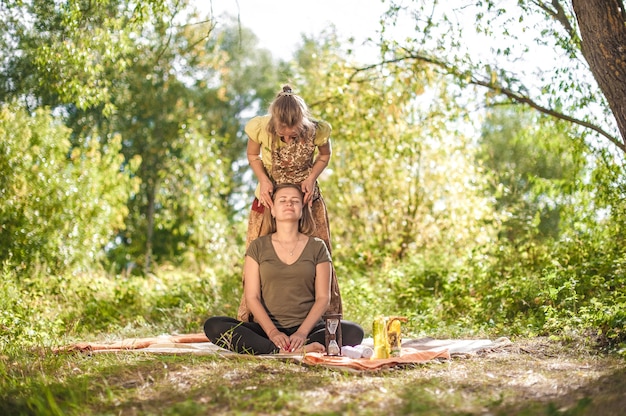 Experienced masseuse gives her client a refreshing massage in the sunlight