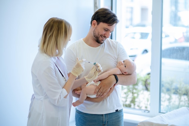 Experienced neonatal doctor preparing to vaccinate the child