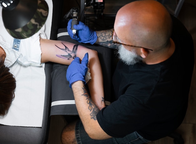 Experienced tattoo artist working on client tattoo