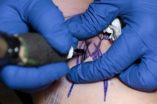 Фото Опытный тату-мастер, работающий над клиентской татуировкой
