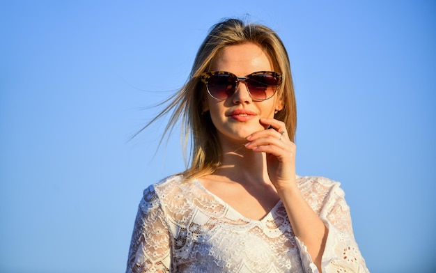 Experienced traveler. beach fashion style. Summer outdoor lifestyle. Happy young woman posing over blue sky. pretty young beautiful woman in sunglasses. Summer outfit. Portrait of the beautiful girl.