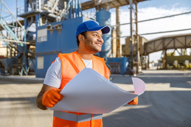 Experienced worker standing in front of large plant