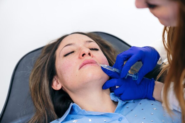 Expert aesthetician enhances lip contours using hyaluronic acid injections