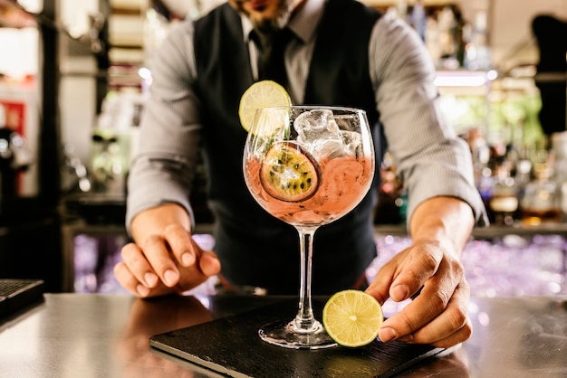 Expert barman is making cocktail at night club