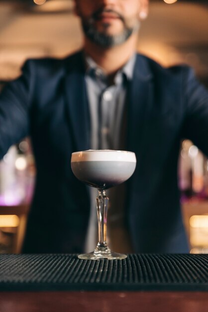 Опытный бармен делает коктейль в ночном клубе.
